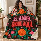 El Amor Sigue Aquí blanket, wrapped around a reader